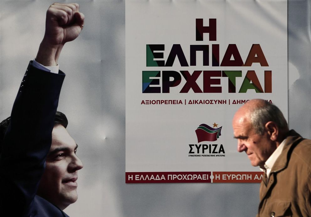 Un hombre camina ante un cartel electoral con la imagen de Tsipras en Atenas (Reuters).