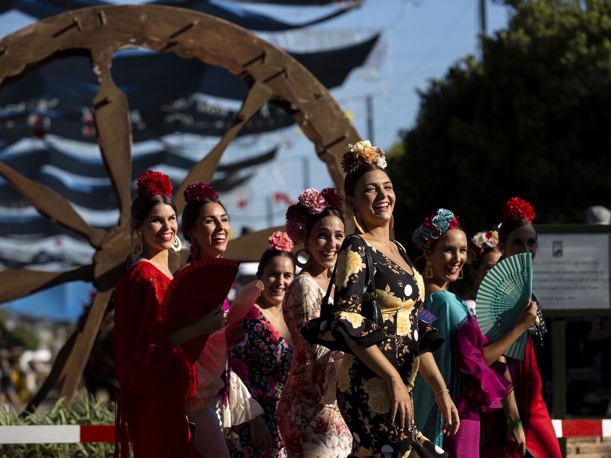 Foto: Varias mujeres vestidas de flamenca en la Feria de Málaga (EFE/Pérez)