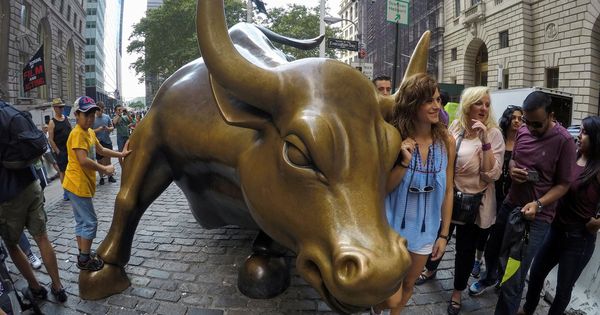 Foto: Un grupo de personas posa con el toro de Wall Street. (EFE)