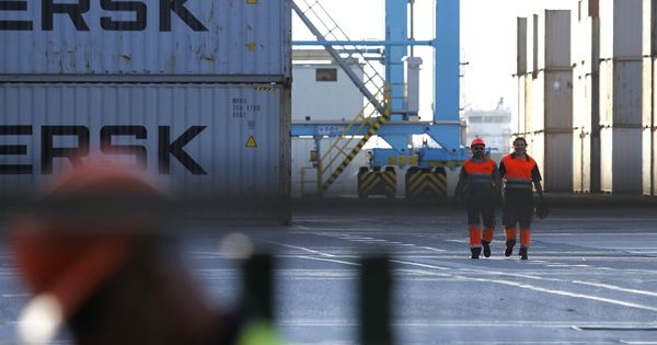 Foto: Dos trabajadores caminan por la terminal del puerto de Algeciras. (EFE)