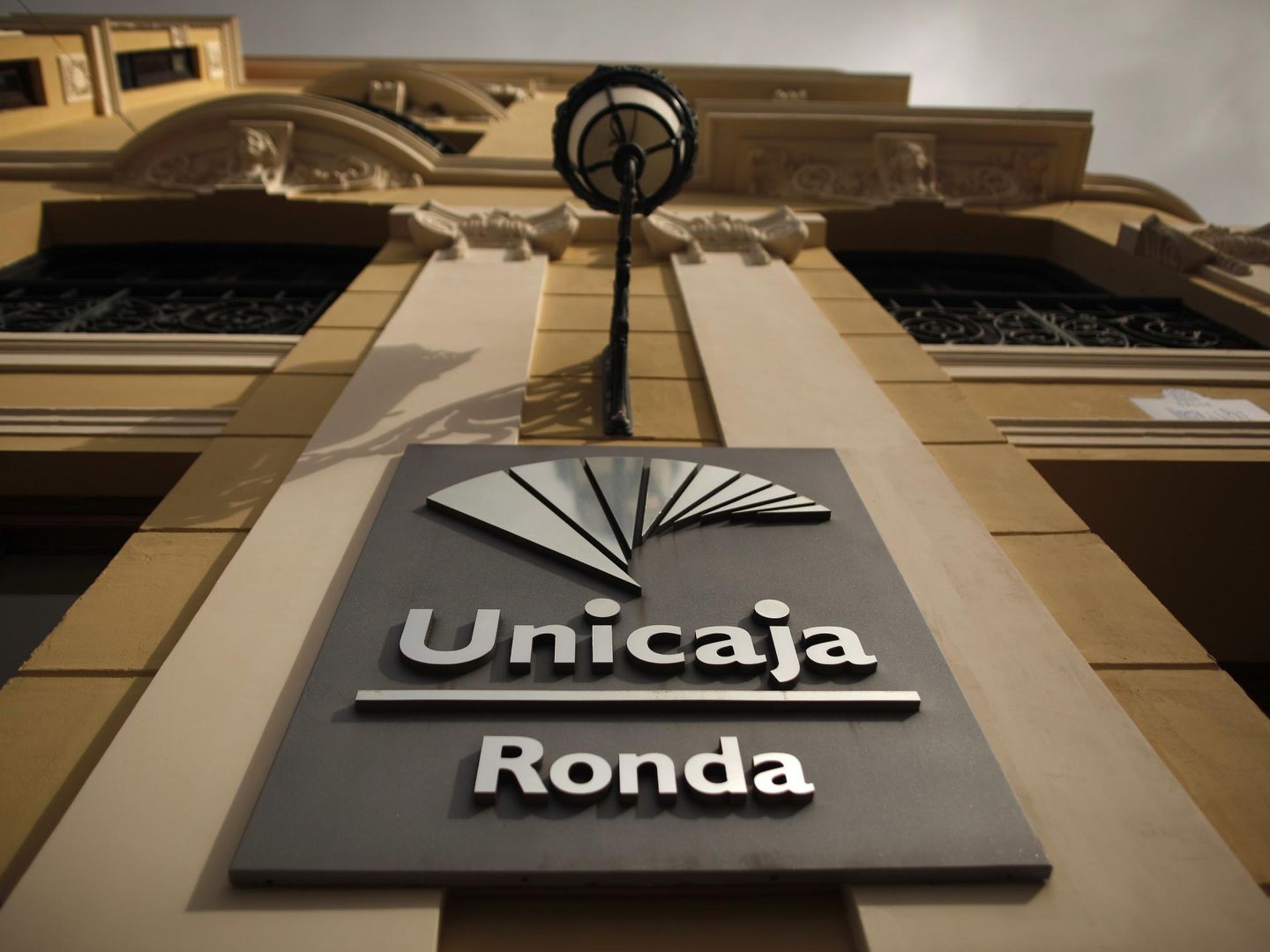The logo of Unicaja bank is seen on the facade of a Unicaja bank branch in downtown Ronda, near Malaga January 29, 2014. Spain's bank restructuring fund FROB has committed to pay up to 319 million euros (6 million) in state aid to lender Unicaja to absorb smaller peer Banco Ceiss and avoid the latter's nationalisation. REUTERS/Jon Nazca (SPAIN - Tags: BUSINESS LOGO)