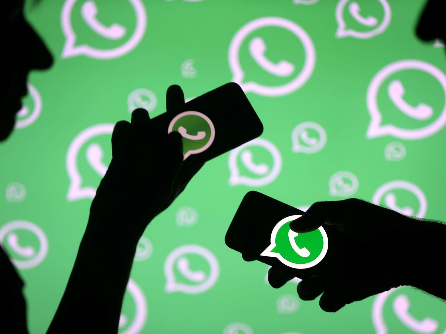 FILE PHOTO: Men pose with smartphones in front of displayed Whatsapp logo in this illustration September 14, 2017. REUTERS Dado Ruvic File Photo