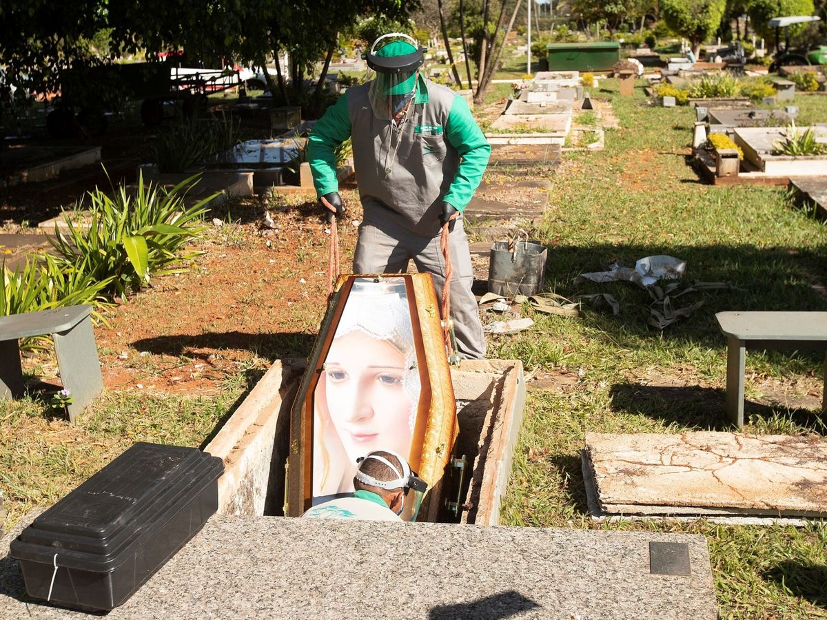 Foto: Trabajadores del cementerio Campo de Esperanza entierran una víctima de coronavirus este lunes, en Brasilia (Brasil) (EFE)