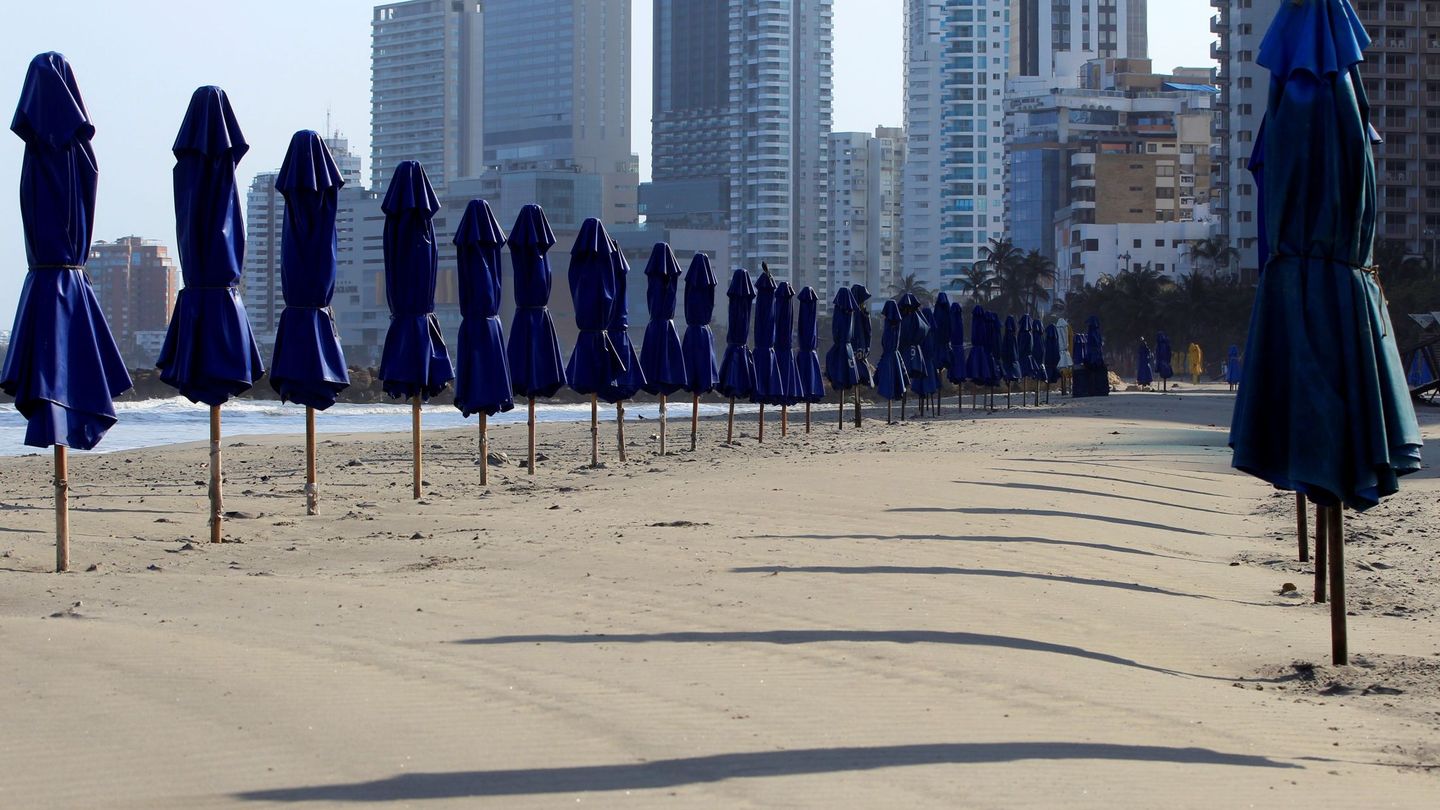Sombrillas cerradas en una playa desierta. (EFE)