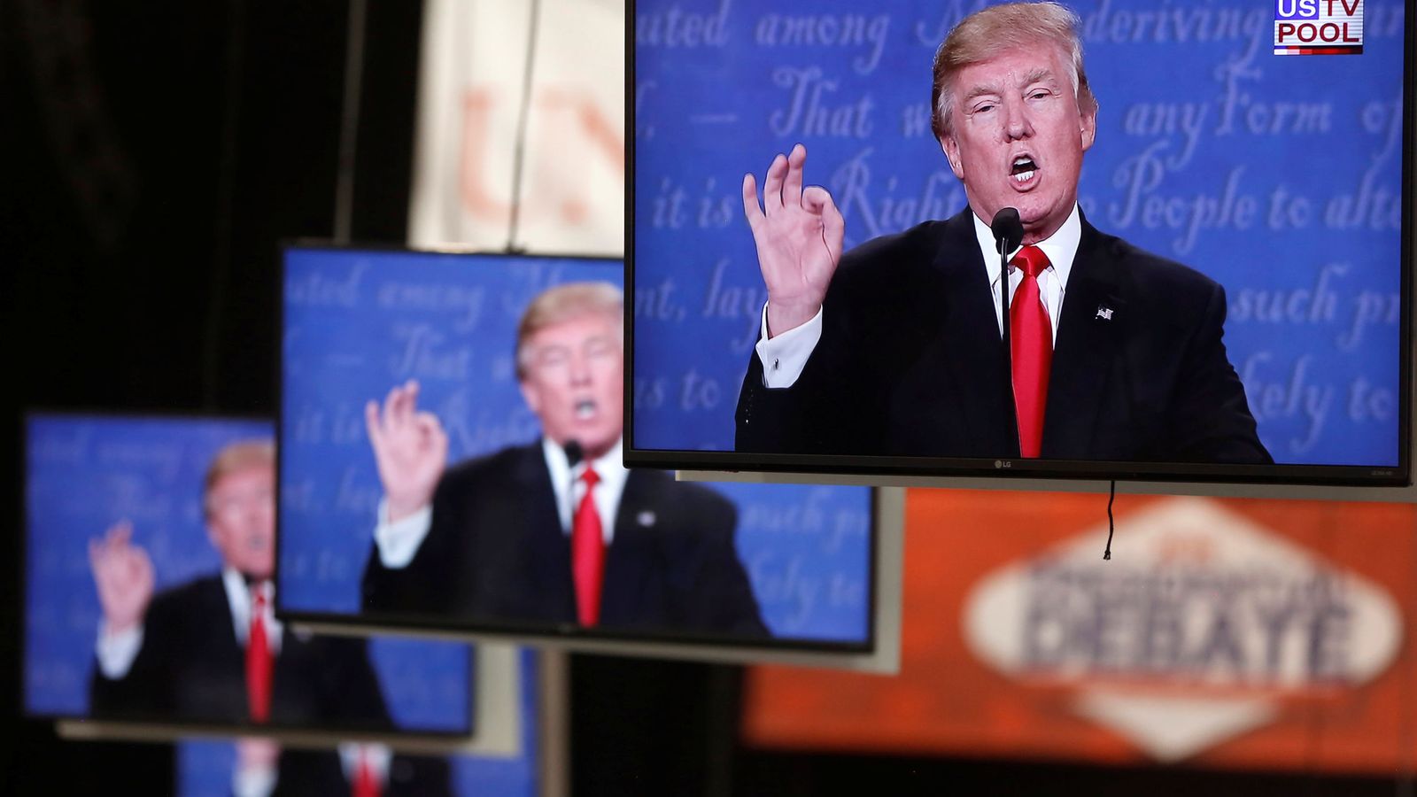 Foto: Donald Trump durante el último debate presidencial, en varios monitores de la Universidad de Nevada. (Reuters)