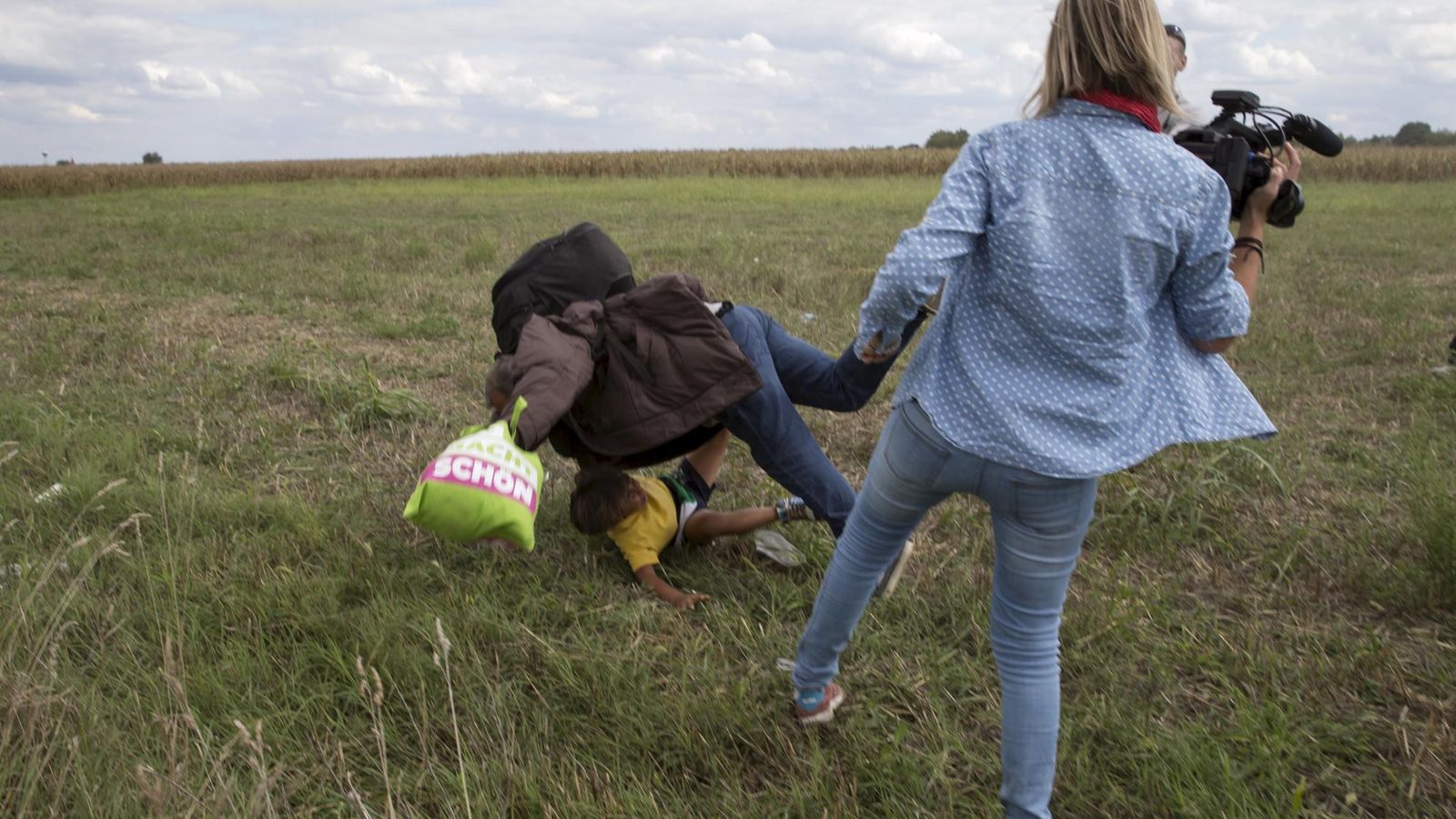 Foto: La periodista Petra Laszlo haciendo la zancadilla a un padre y su hijo. (Reuters)