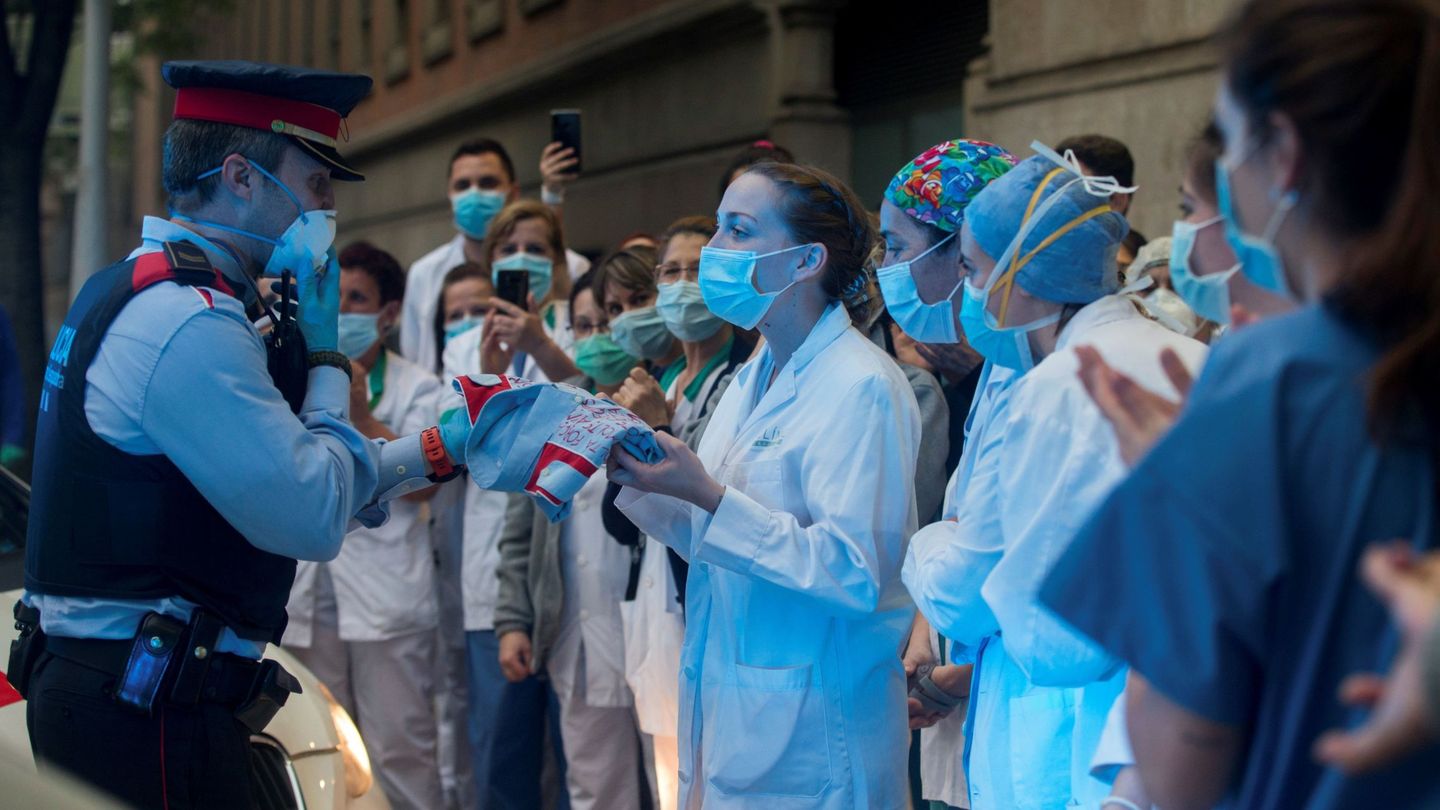 Sanitarios del Clínic de Barcelona reciben una camisa de los Mossos como reconocimiento a su labor. (EFE)