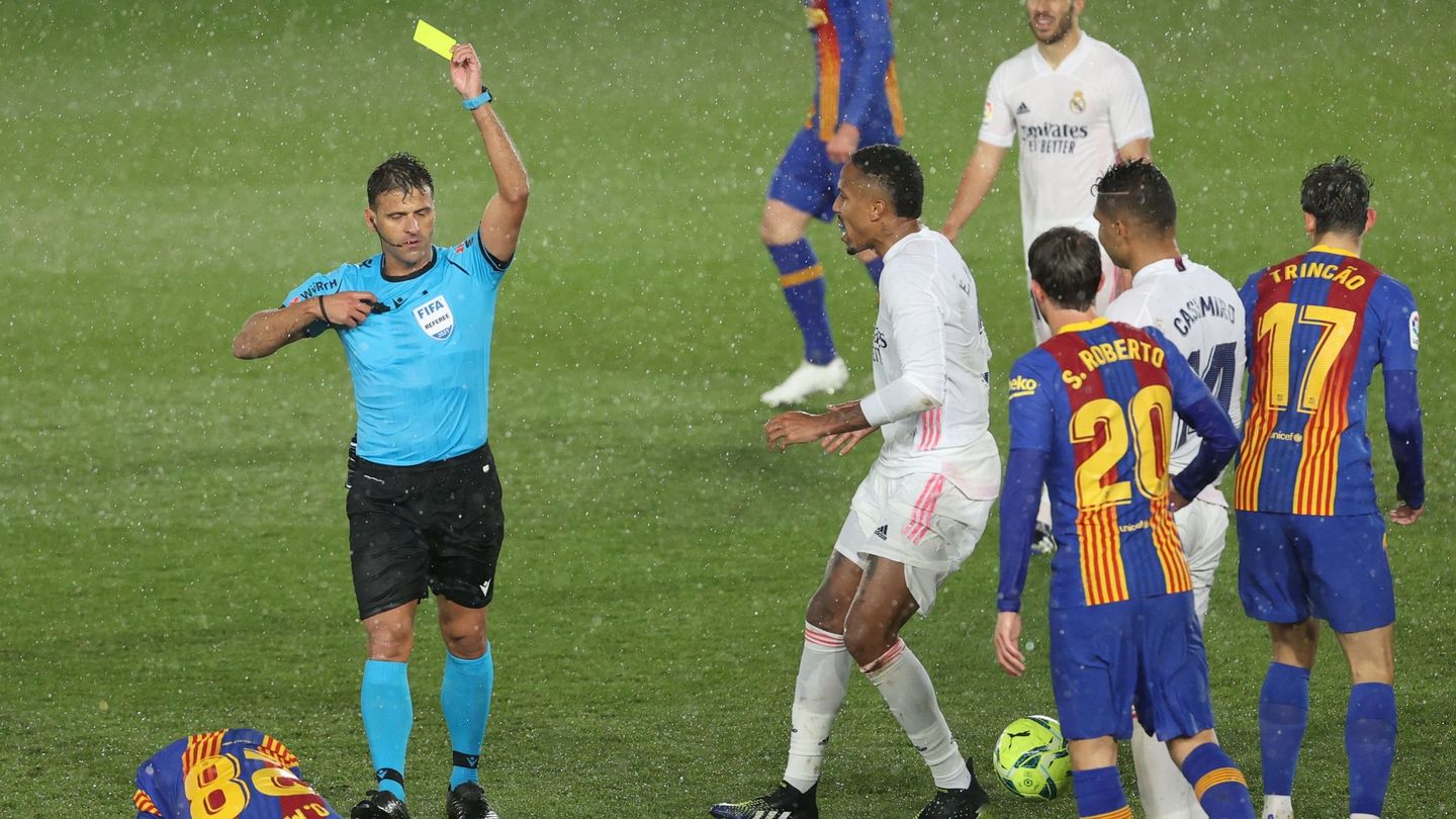 Jesús Gil Manzano muestra una cartulina amarilla en el partido entre el Real Madrid y el Barcelona. (EFE)