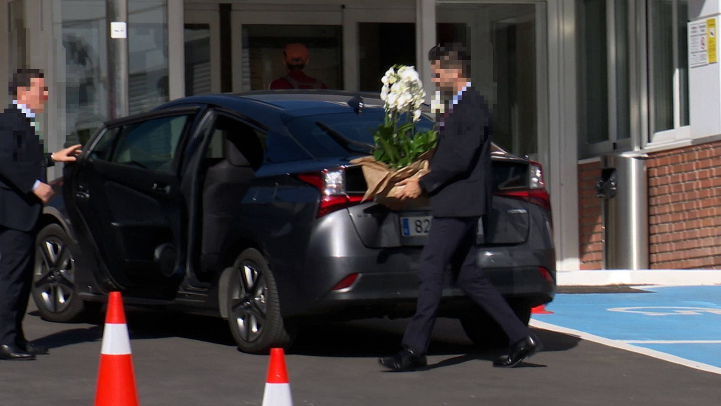 Los escoltas de la reina Sofía introducen en el maletero los ramos de flores.(Gtres)