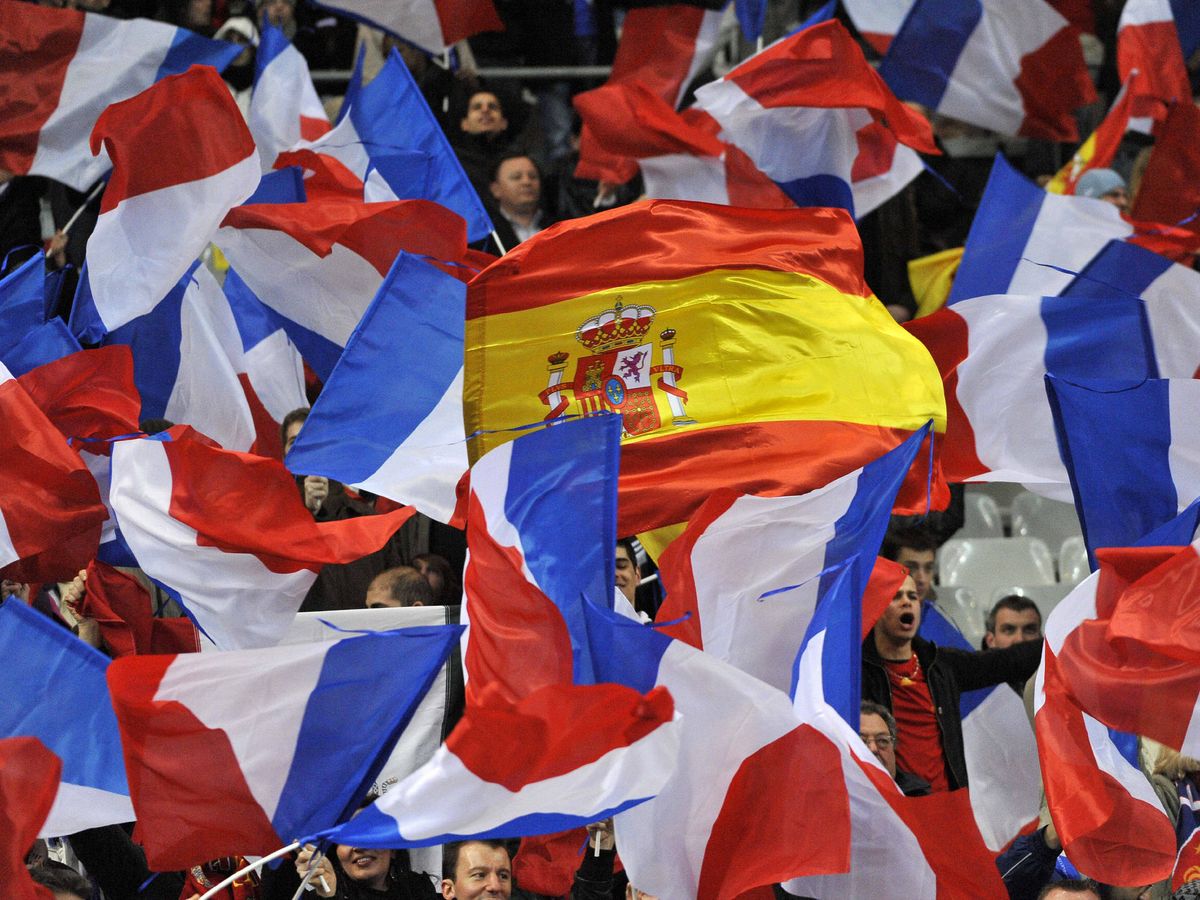Foto: Una bandera española es rodeada por francesas durante un partido amistoso internacional de fútbol entre las selecciones de Francia y España en Saint Denis. (EFE/Horacio Villalobos)