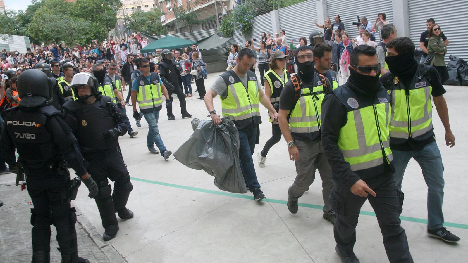 Foto: Agentes de la Policía Nacional y la Guardia Civil retiran urnas del IES Tarragona el 1-O. (EFE) 