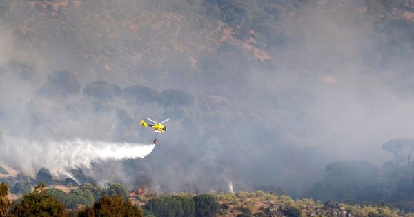 Foto: Un helicóptero trabaja en las labores de extinción del incendio en la localidad abulense de El Hoyo de Pinares (Efe)