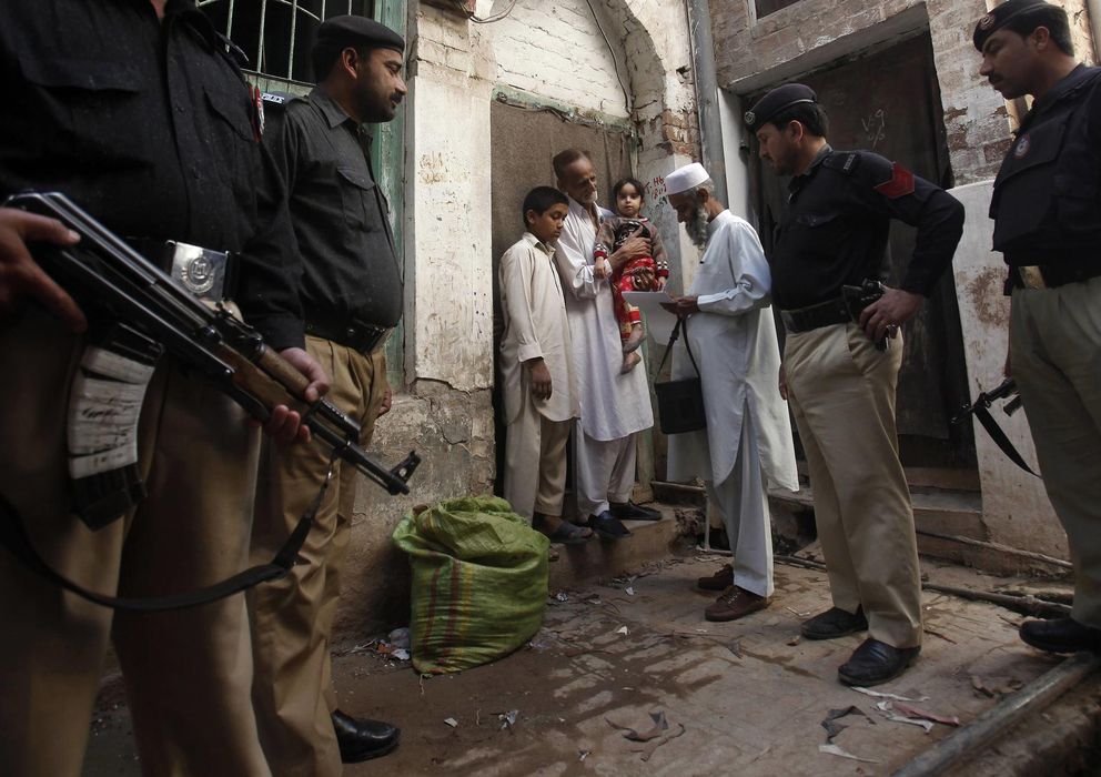 Foto: La policía protege a un trabajador de la campaña contra la polio en Peshawar el pasado 30 de marzo. (Reuters)