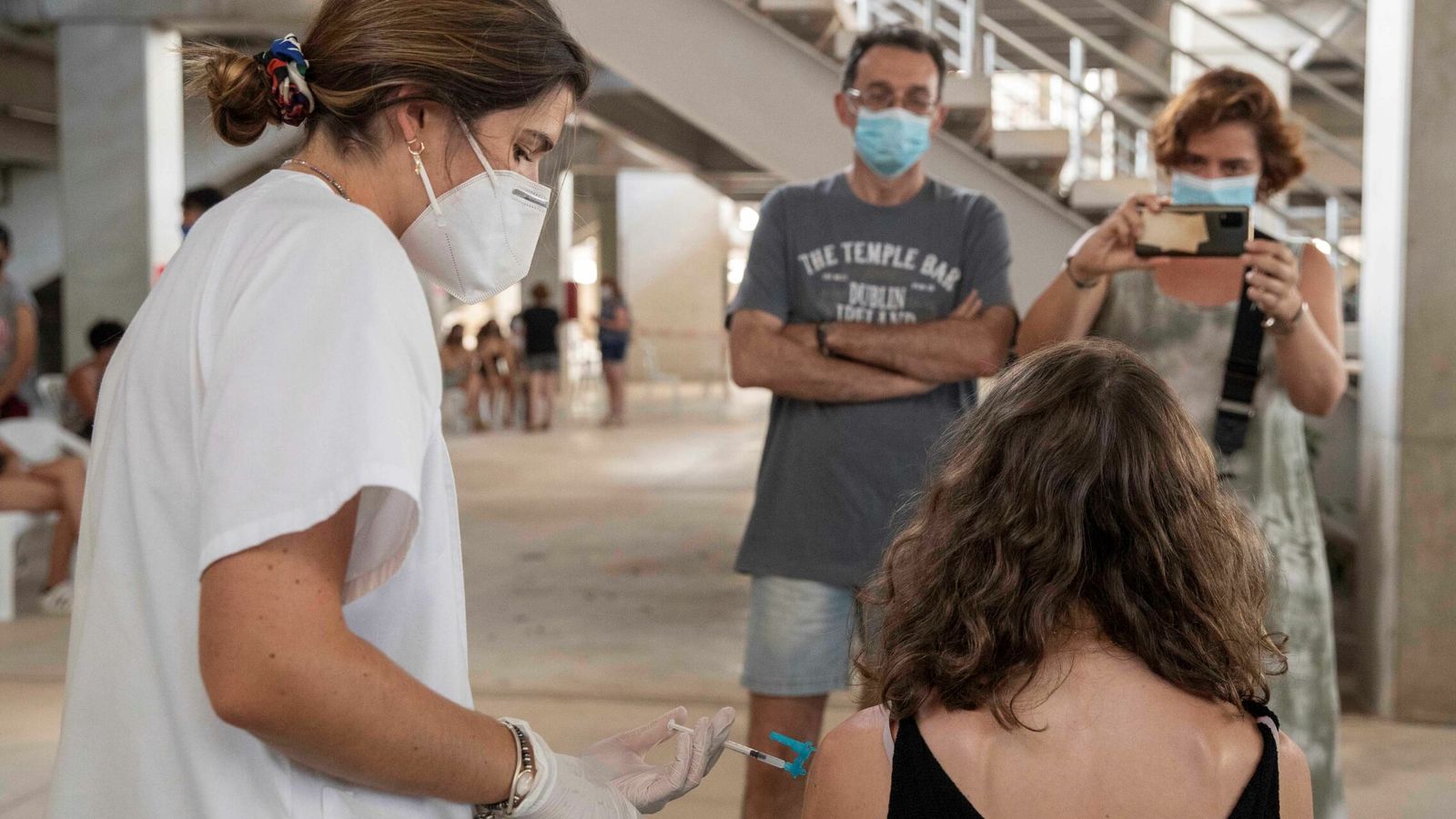 Una enfermera administra la vacuna de Moderna a una joven en el estadio Enrique Roca, de Murcia. (EFE)