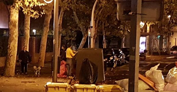 Foto: Dos personas, robando en Madrid papel y cartón de un contenedor.