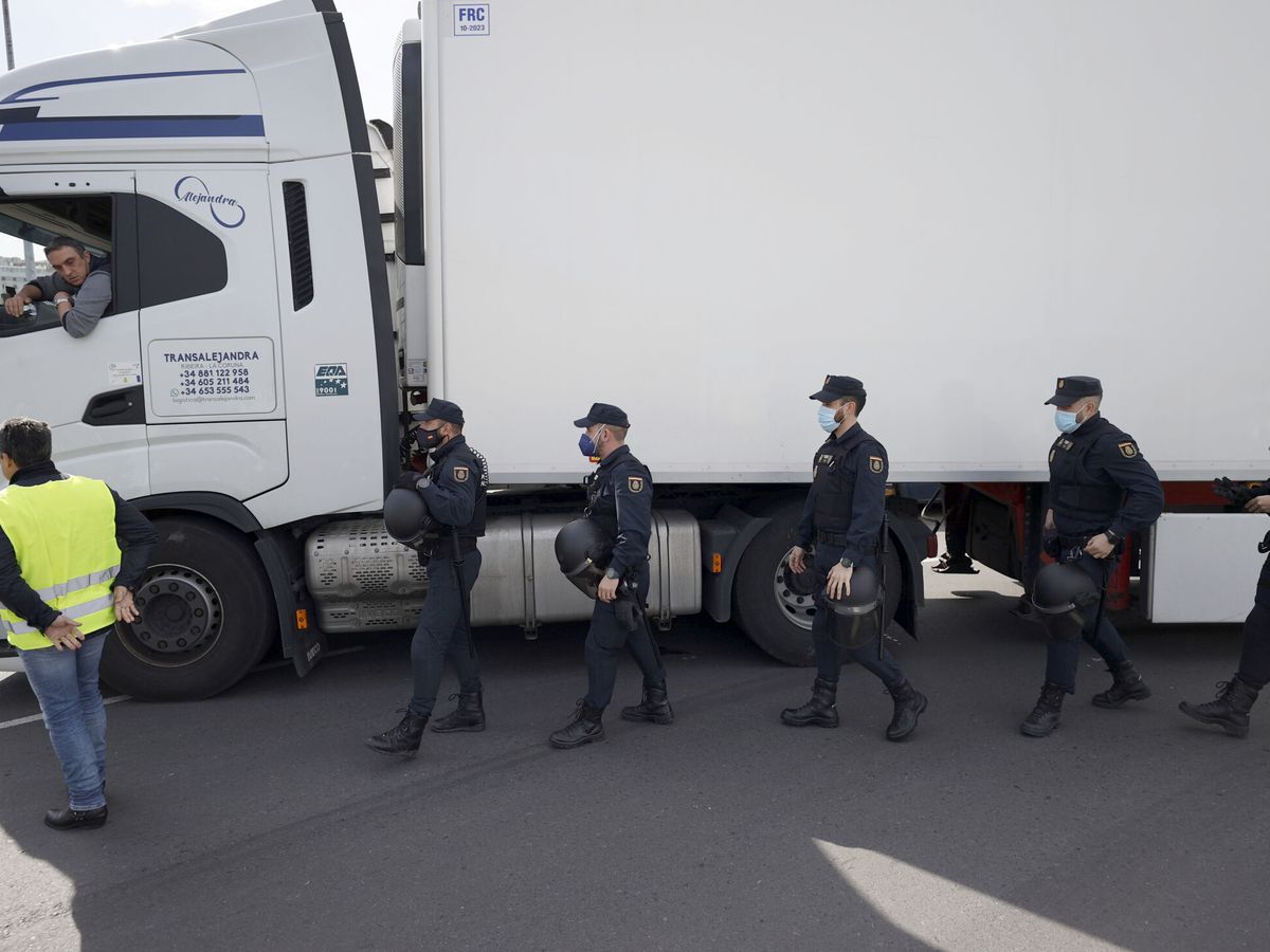 Foto:  Agentes del Cuerpo Nacional de Policía escoltaban este lunes a uno de los camiones que ha salido del puerto de A Coruña. (EFE/Cabalar)