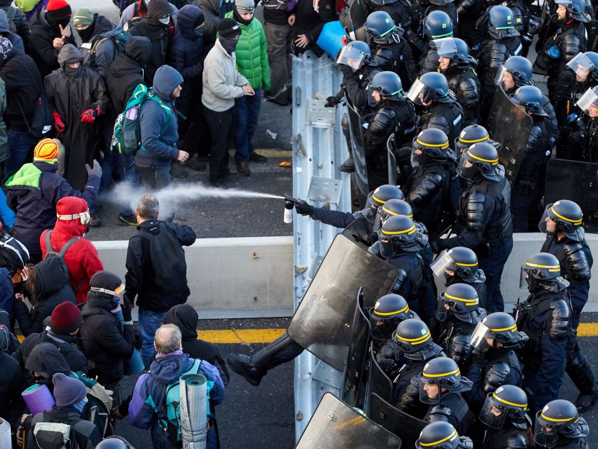 Foto: Antidisturbios franceses desalojan a los manifestantes que bloquean el paso fronterizo de la autopista AP-7. (EFE)