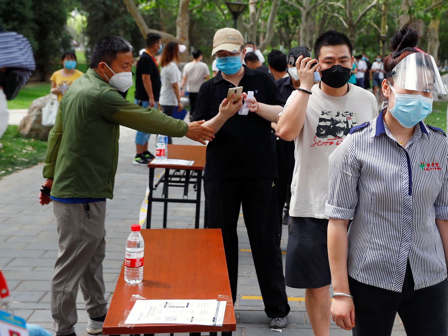 Un grupo de personas con mascarillas y guardando la distancia de seguridad. (Reuters)
