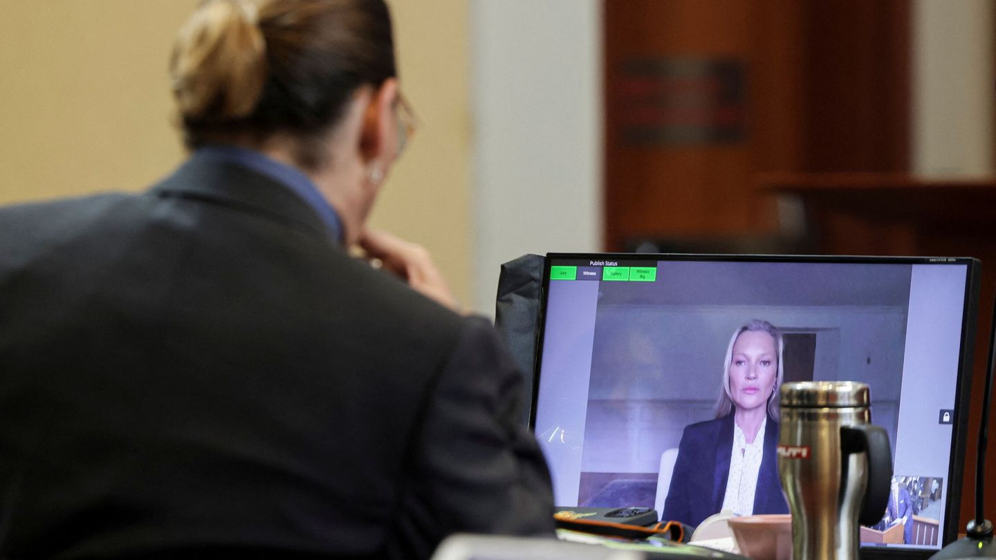 Johnny Depp sigue la comparecencia de Kate Moss desde su sitio en el juzgado a través de una pantalla. (Reuters)