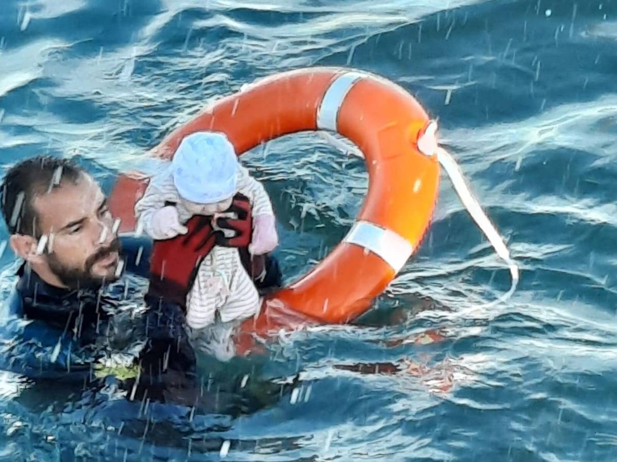 Foto: Un agente de la Guardia Civil rescata a un bebé del agua durante el paso de inmigrantes a nado en Ceuta (Twitter/Guardia Civil)