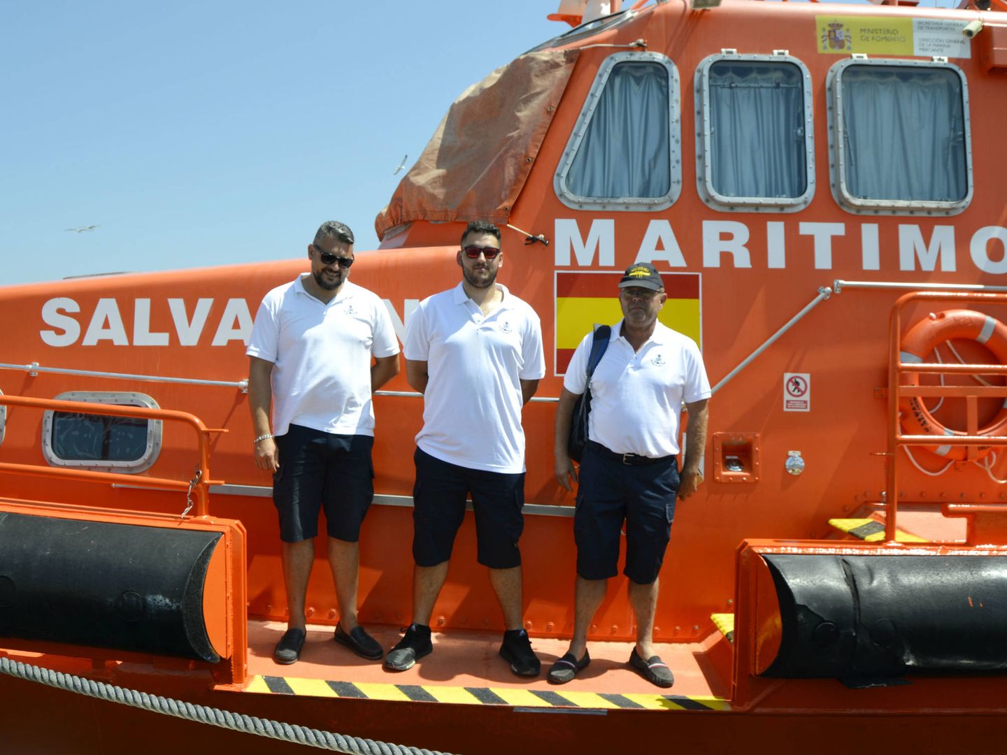 Manolo (centro) junto a dos compañeros en la zona del barco desde donde suben a los rescatados. (M. Z.)