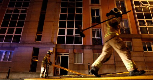 Foto: Bomberos en la vivienda de la mujer hallada muerta en A Coruña. (EFE)