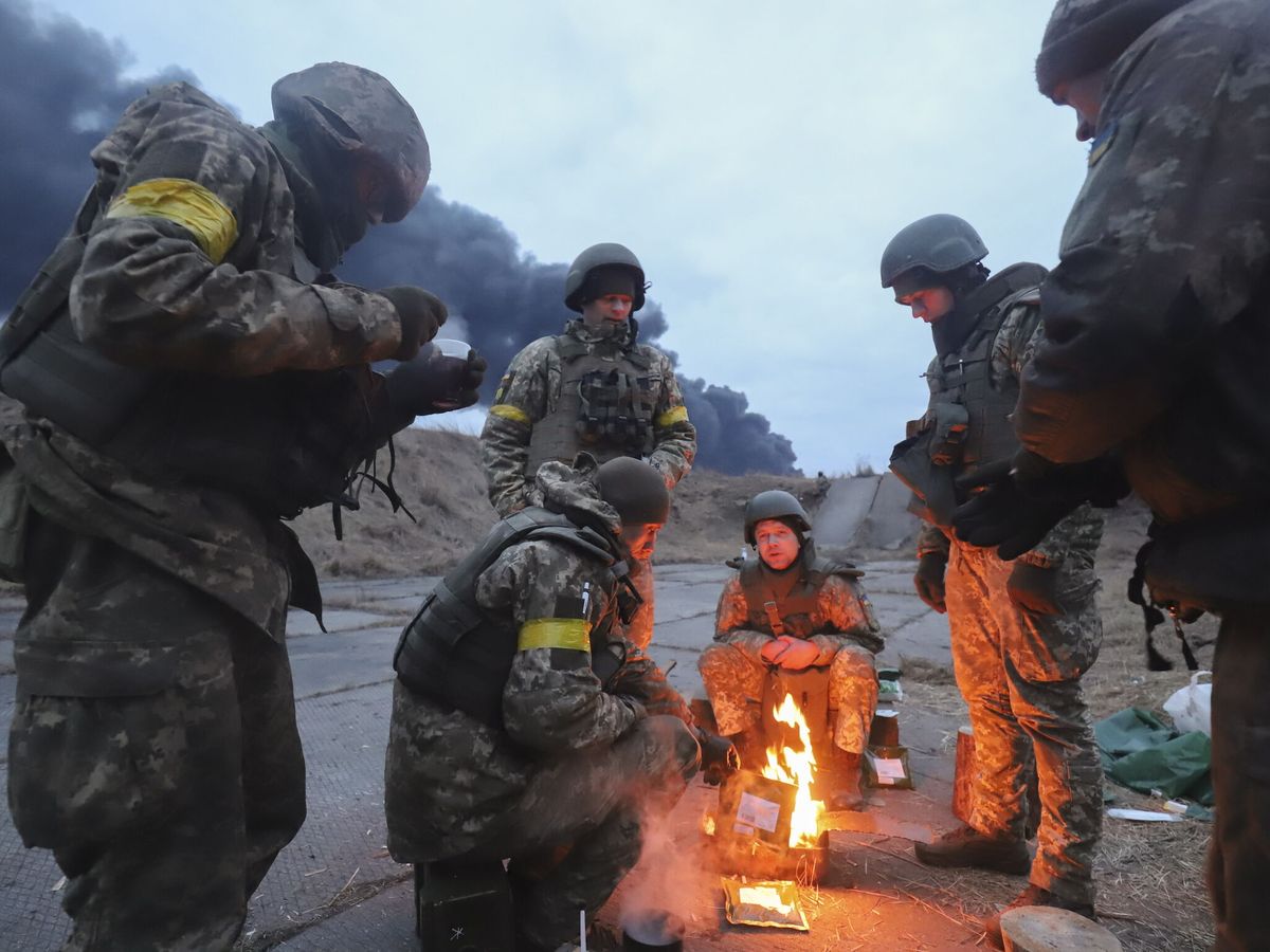 Foto: Soldados ucranianos se calientan cerca de Kiev. (EFE/A. Yakubovych)
