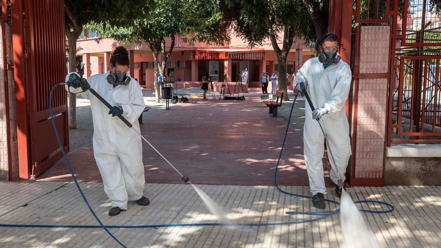 Dos trabajadores del servicio de limpieza del Ayuntamiento de Murcia durante las labores de desinfección del colegio de San Juan. (EFE)
