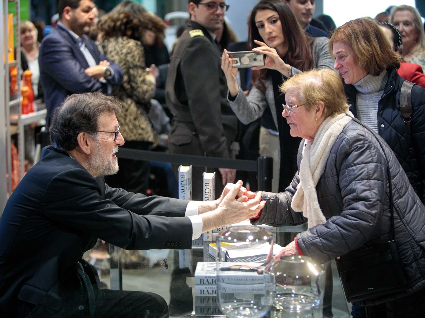 Mariano Rajoy, firmando ejemplares de su libro 'Una España mejor'. (EFE)
