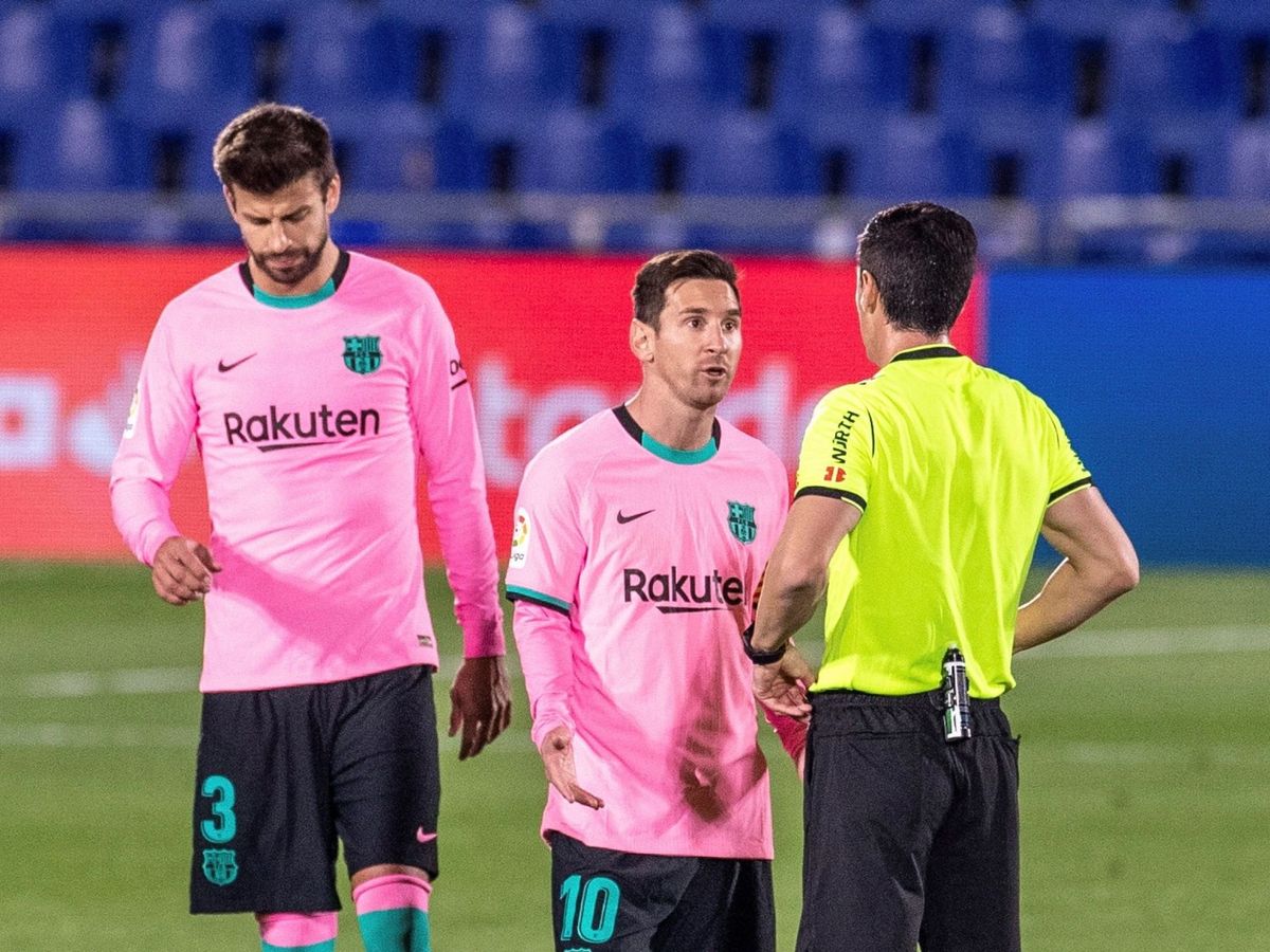 Foto: Messi conversa con el árbitro en presencia de Piqué. (Efe)