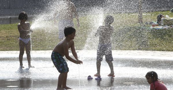 Foto: Varios niños se refrescan bajo el agua de una fuente esta tarde en el parque Madrid Río el pasado verano. (EFE)