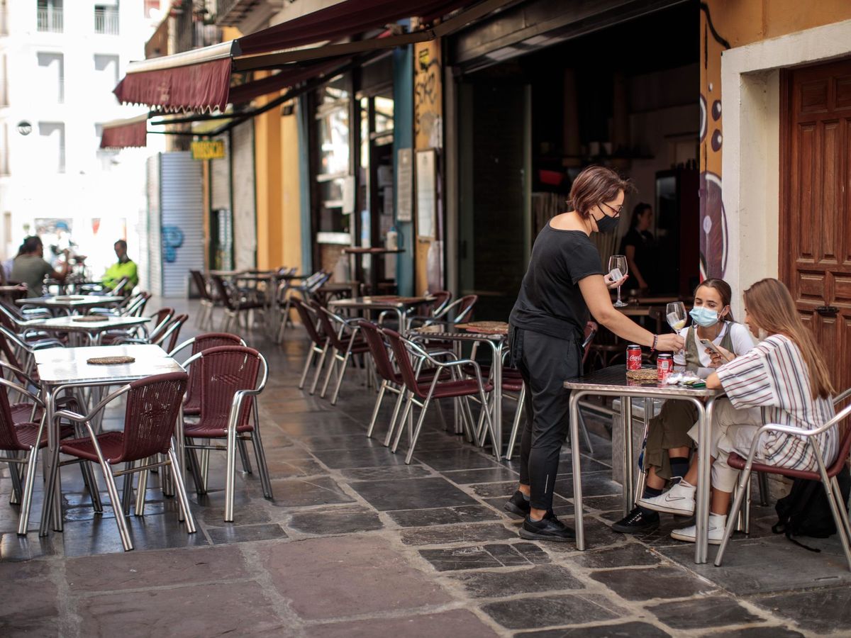 Foto: Una camarera atiende una mesa de una terraza en el centro de Valencia. (EFE)