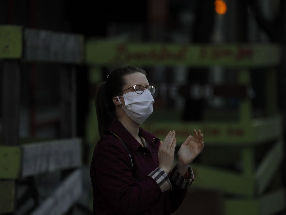 Foto: Una mujer aplaude en apoyo a los trabajadores sanitarios de Nueva York (EFE)