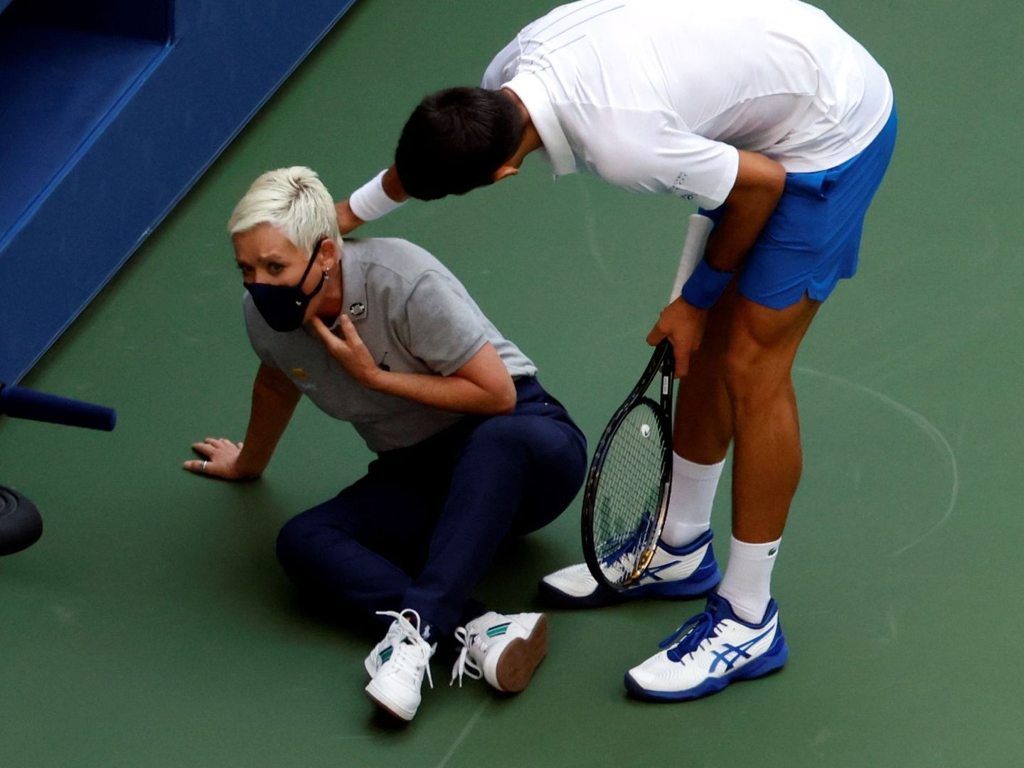 Djokovic intenta ayudar a la juez de línea después de golpearla en la garganta. (Efe)