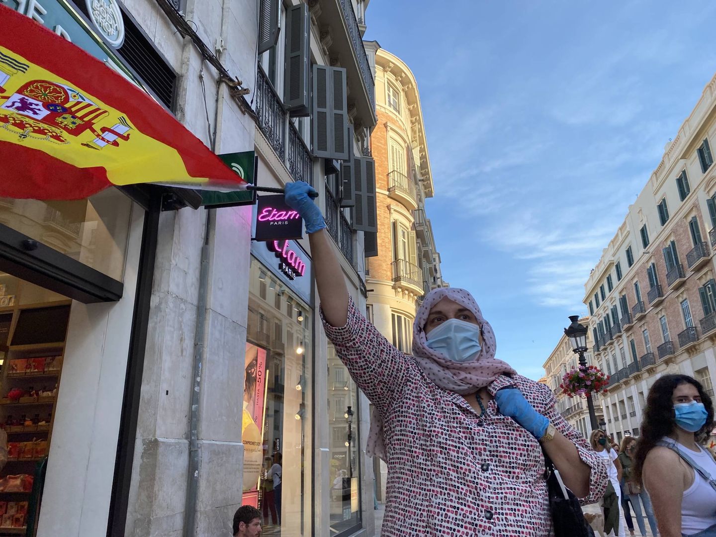 Una mujer agita la bandera de España en la calle Larios. (Agustín Rivera)