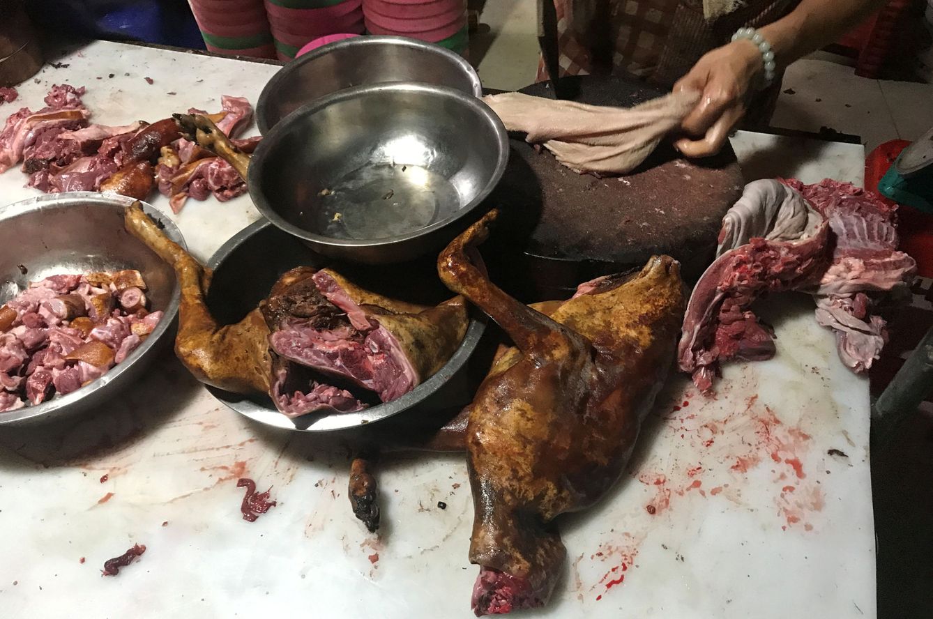 Un hombre corta carne de perro en el festival de Yulin. (Reuters) 