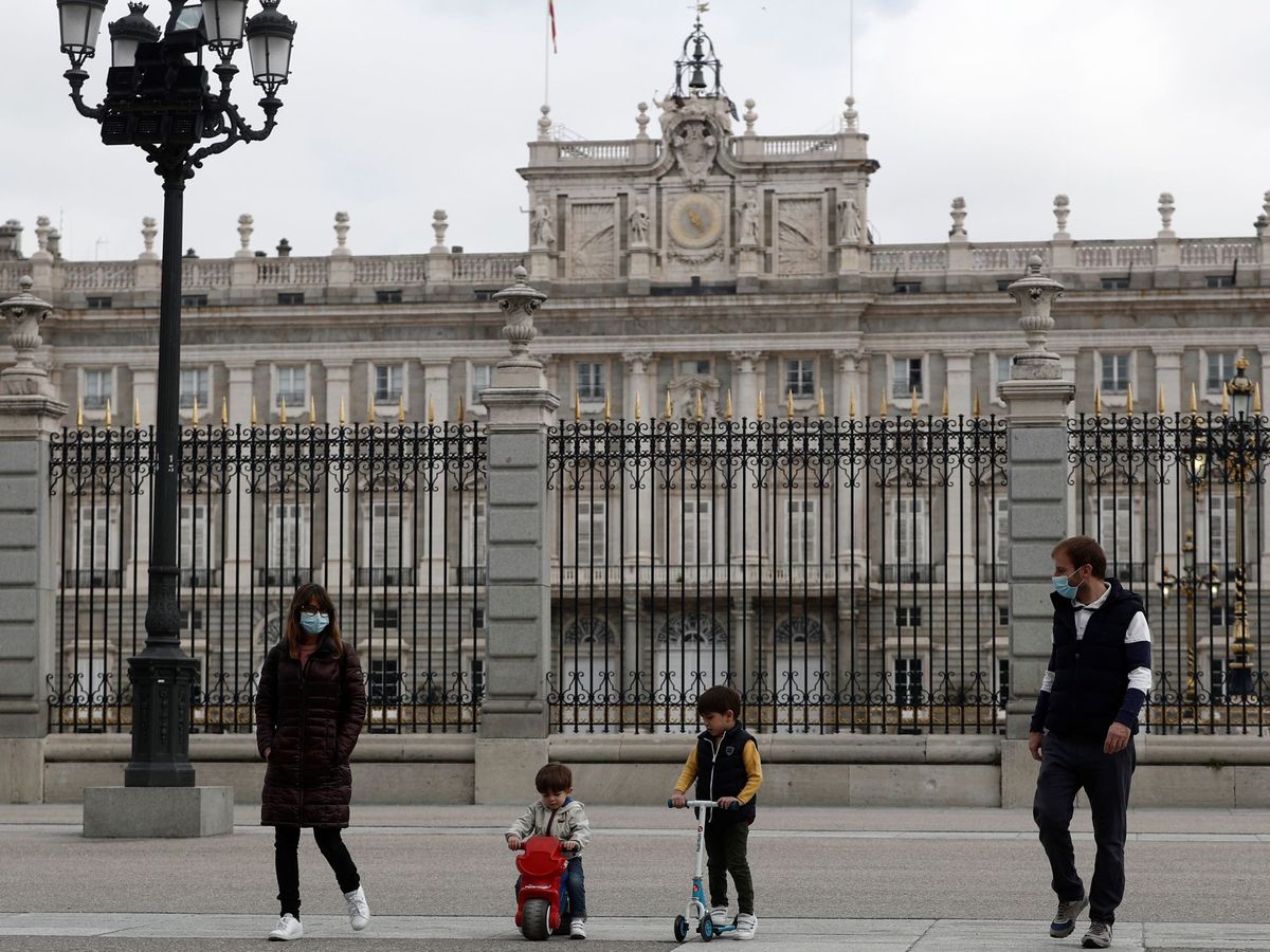 Foto: Unos padres con sus hijos pasean delante del Palacio Real, en Madrid. (EFE)