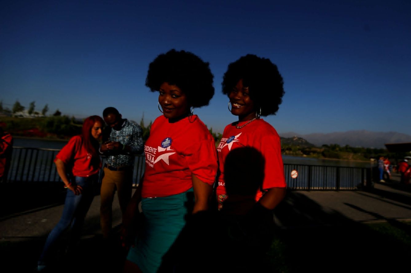 Haitianos residentes en Chile posan para un fotógrafo en un mitin electoral de Sebastián Piñera en Santiago. (Reuters)