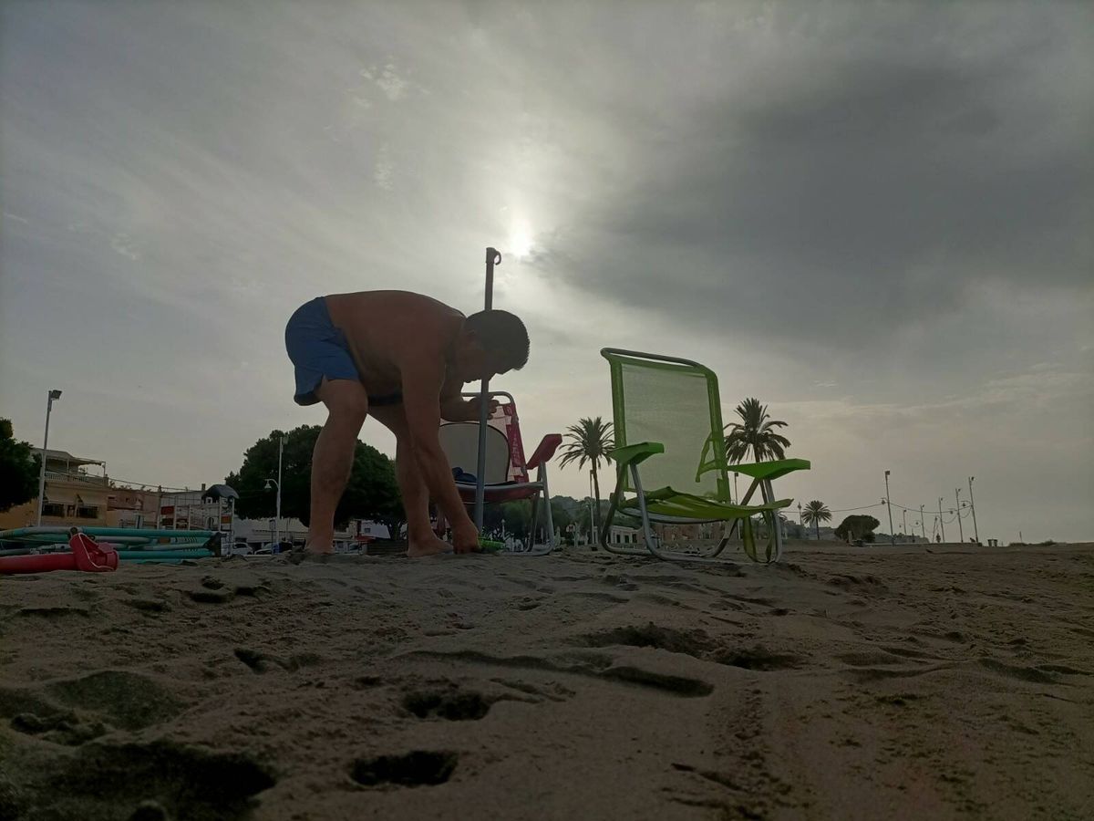 Foto: Juan Manuel plantando su sombrilla en la arena. (P.D.A.)