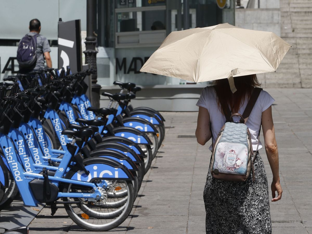Foto: Una viandante se protege del sol con un paraguas mientras camina por el centro de Madrid. (EFE/Mariscal)