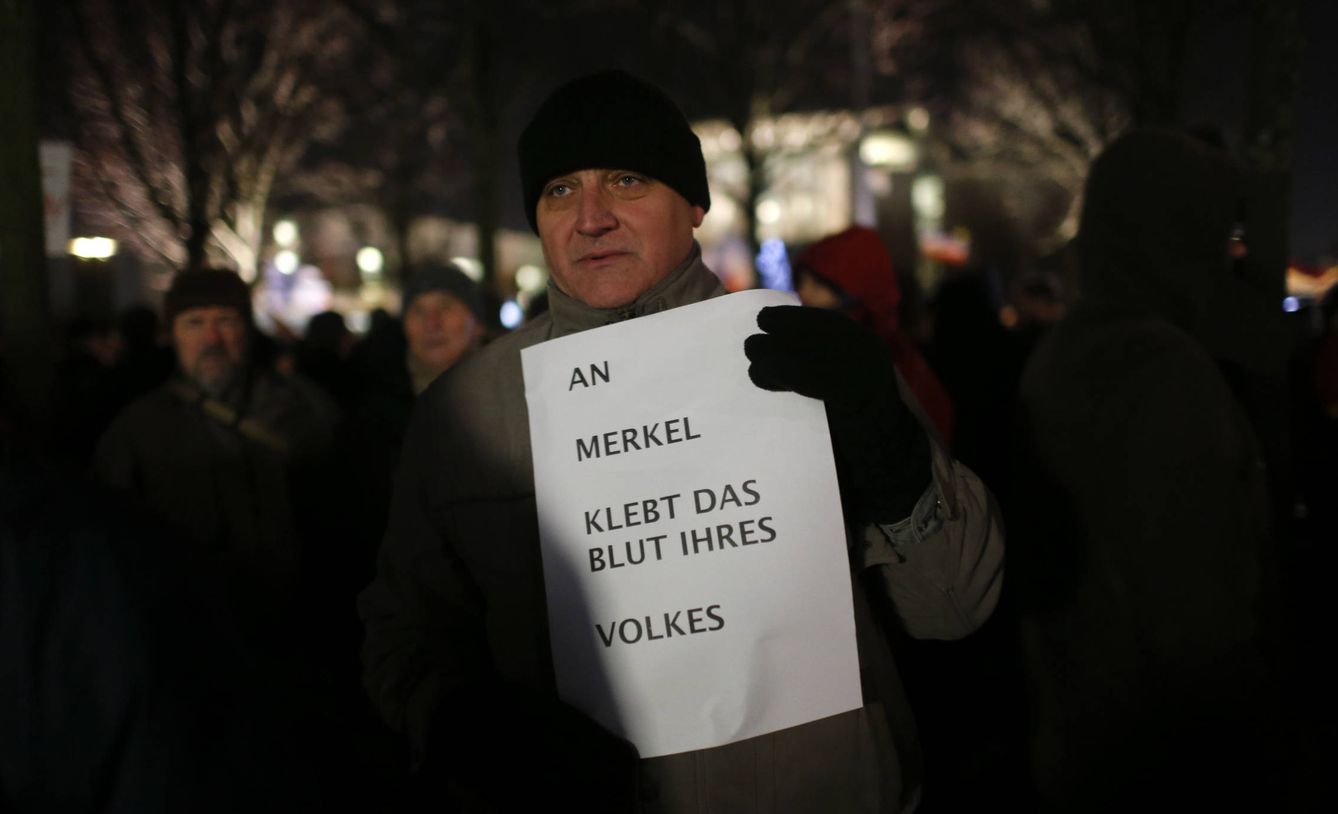 Un votante de AfD con un cartel que reza: 'En las manos de Merkel hay sangre de nuestra gente'. (Reuters) 
