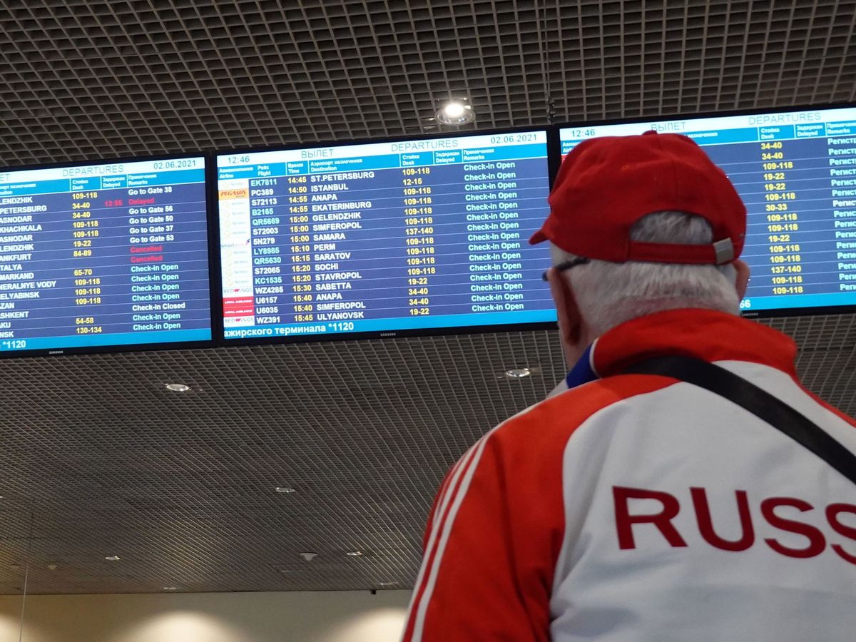 Foto: Un hombre mira las pantallas del aeropuerto de Moscú. (EFE/MAXIM SHIPENKOV)