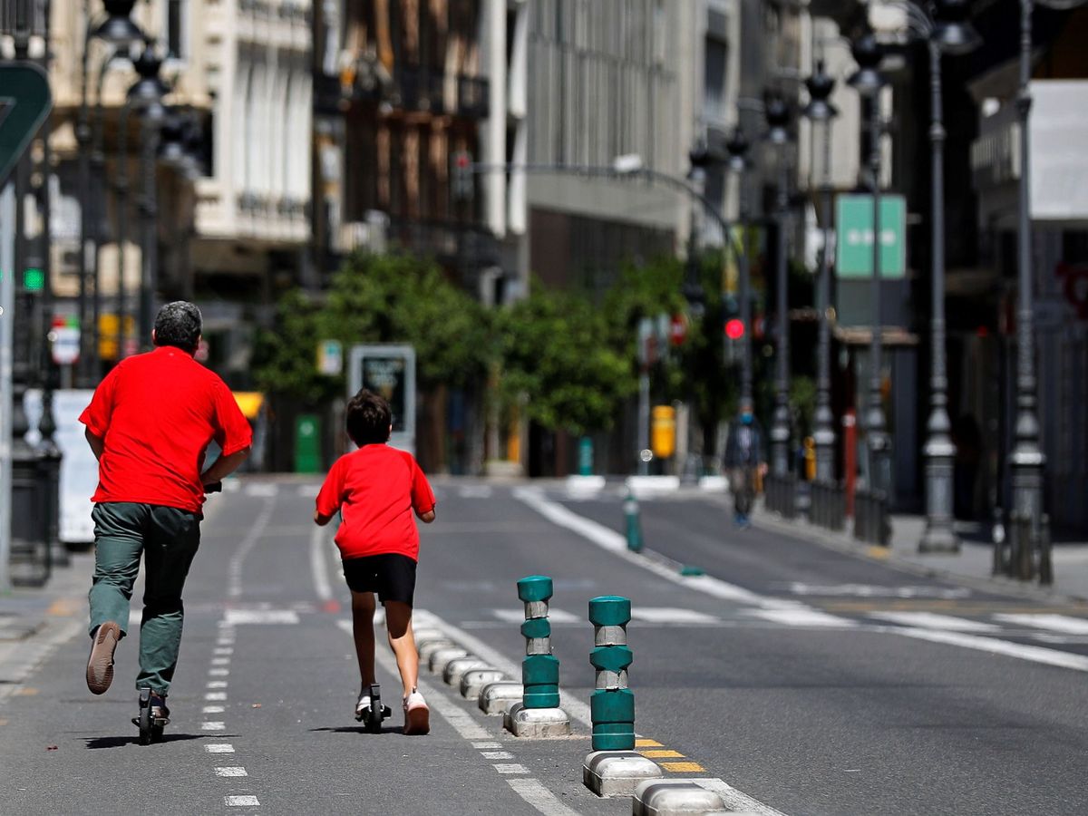 Foto: Un hombre patina con un niño en una calle de Valencia. (EFE)