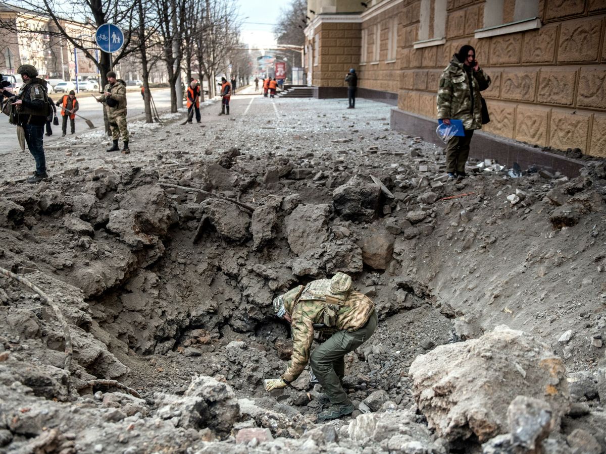 Foto: Un investigador ruso examina el cráter de un bombardeo en el centro de Donetsk. (EFE/Valery Melnikov)