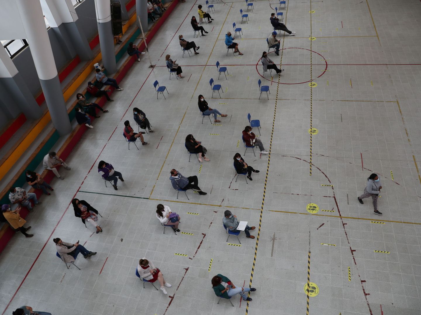 Profesores esperan para recibir una dosis de la vacuna en un centro deportivo de Santiago de Chile. (Reuters)