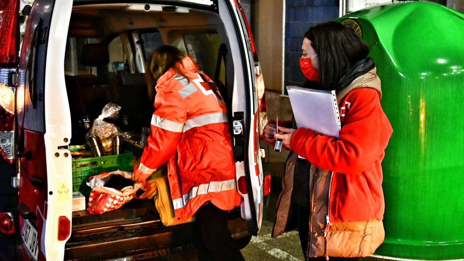 Dos voluntarias de Cruz Roja reparten comida entre personas sin hogar. (Cruz Roja)