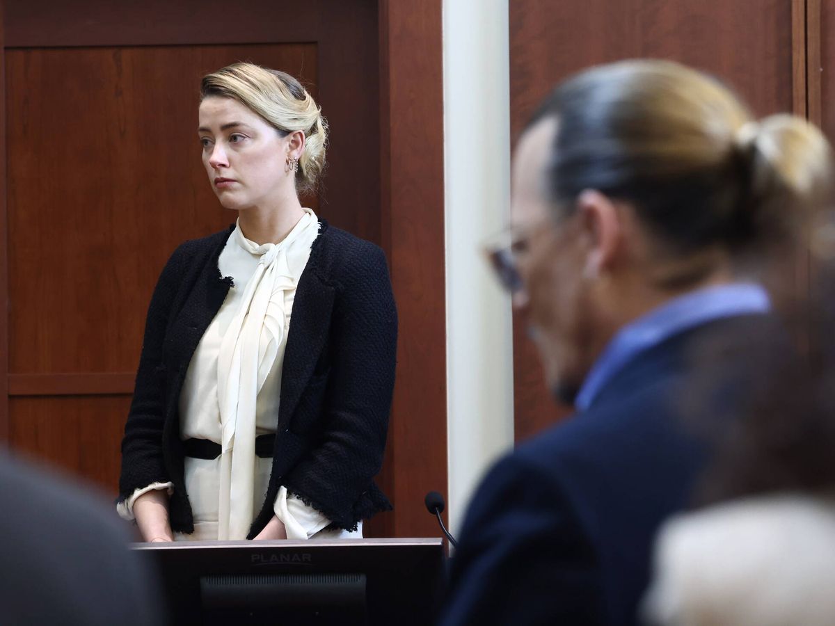 Foto: Amber Heard testifica en el juicio, con Johnny Depp en primer plano. (EFE/Jim Lo Scalzo)
