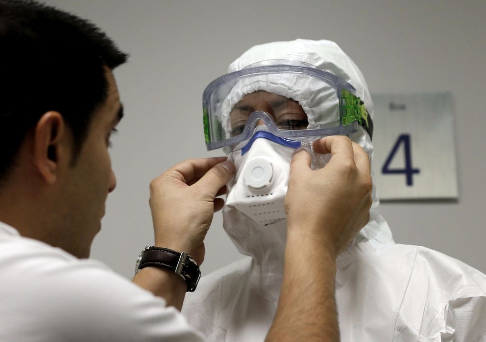 Foto: Una auxilar de clínica se coloca el traje de protección individual ante posibles casos de ébola. (Efe/Juan Caros Cárdenas)
