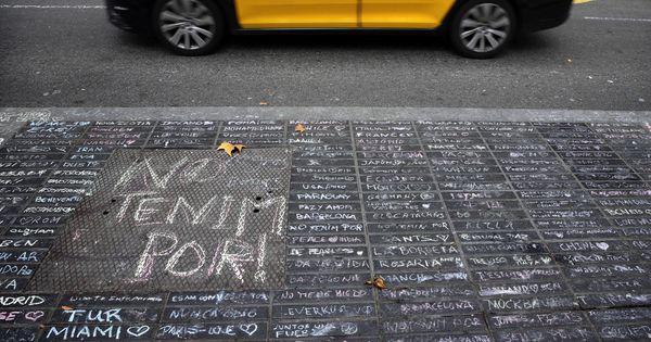 Foto: Un taxi pasa junto a los mensajes de apoyo escritos con tiza en una acera de las Ramblas de Barcelona. (EFE)