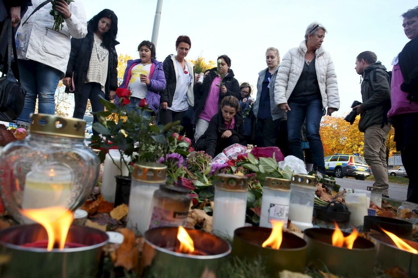 Suecos encienden velas a las puertas de la escuela Kronan de Trollhättan tras el ataque, el 23 de octubre de 2015. (Reuters)